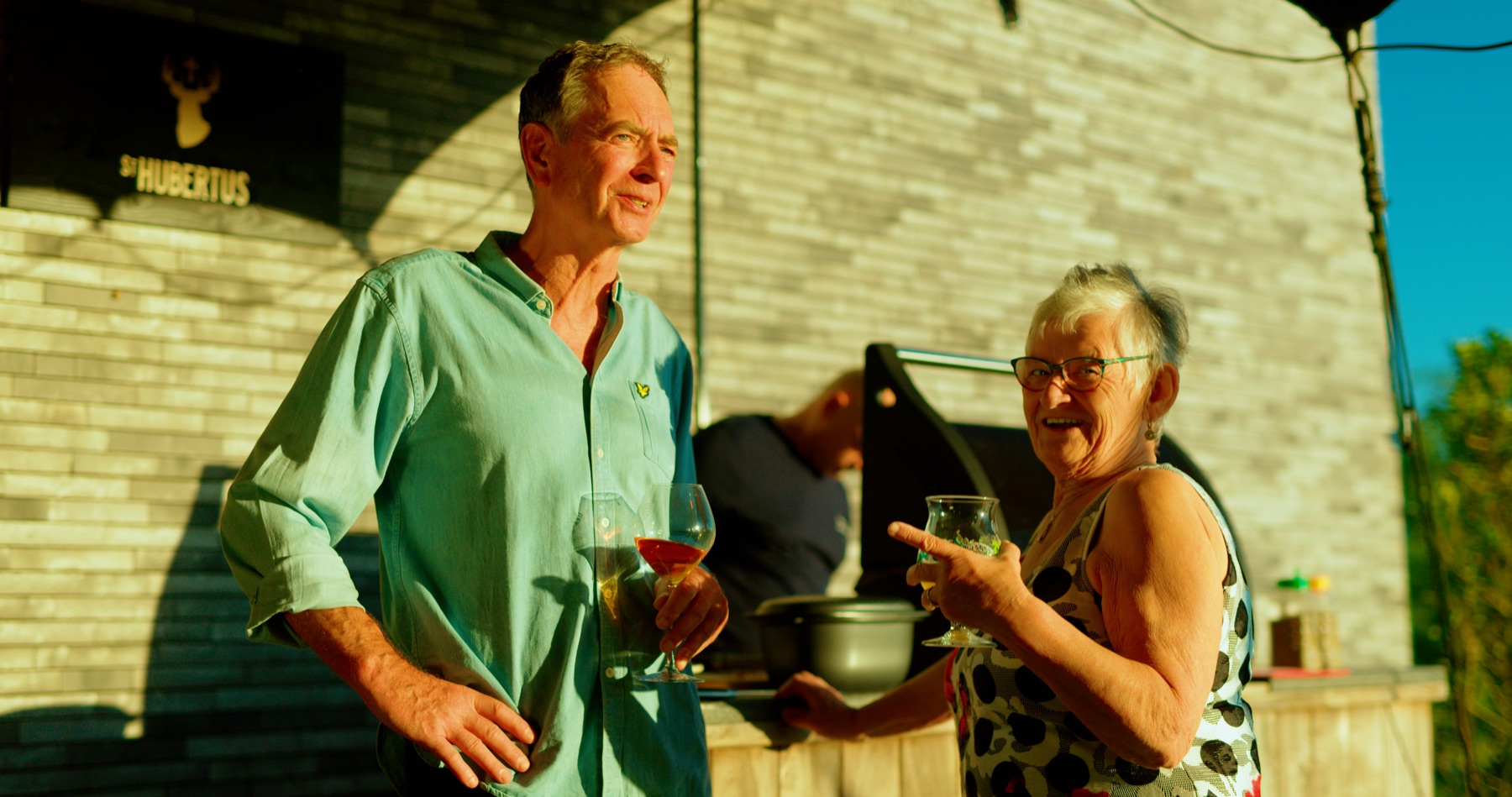Een grootvader en grootmoeder heffen het glas tijdens een familiefeest